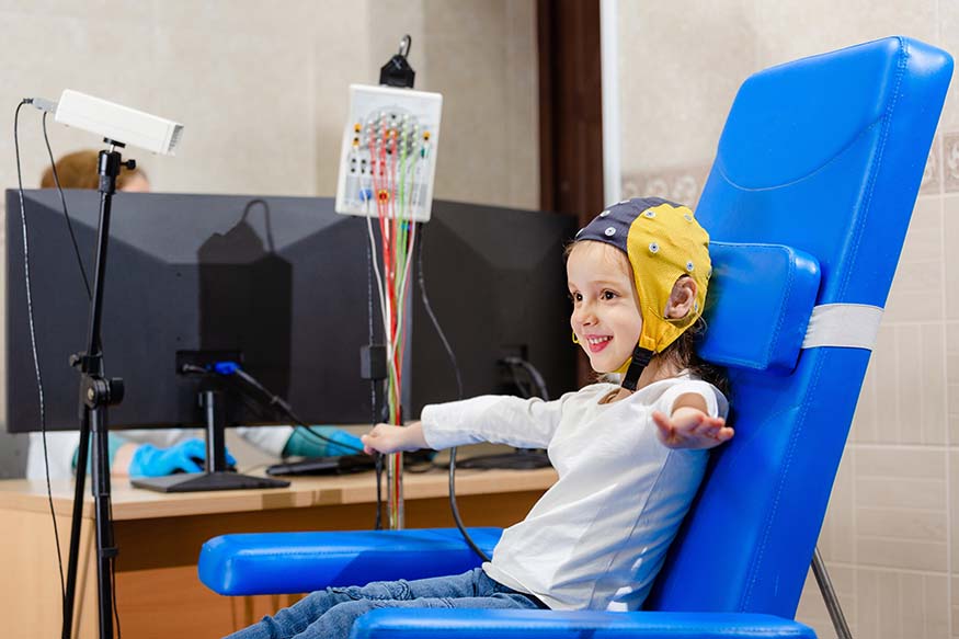 A child wearing an EEG cap undergoing language tests.