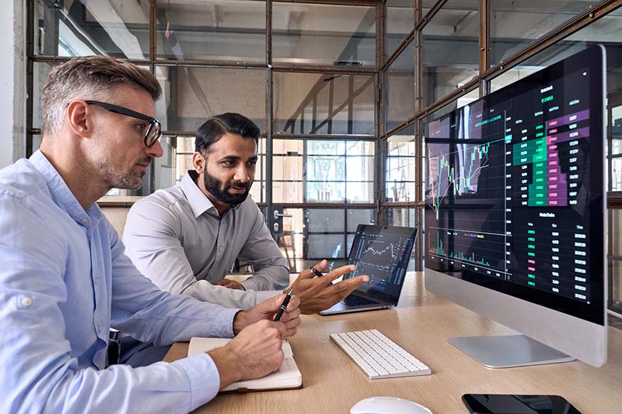 Two researchers looking at data on a monitor.