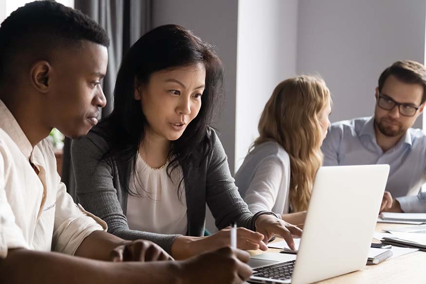 Researchers discussing data being displayed on a laptop.